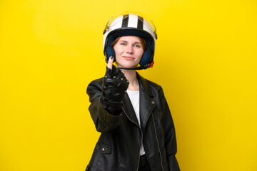 Young English woman with a motorcycle helmet isolated on yellow background doing coming gesture