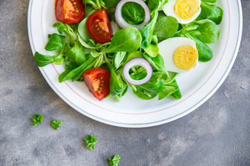 salad egg, vegetables, tomato, onion, leaves lettuce green mix petals fresh healthy meal food snack diet on the table copy space food background rustic top view keto or paleo diet