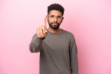 Young Brazilian man isolated on pink background counting one with serious expression