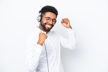 Telemarketer Brazilian man working with a headset isolated on white background celebrating a victory