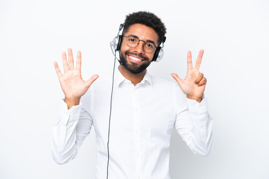 Telemarketer Brazilian man working with a headset isolated on white background counting eight with fingers