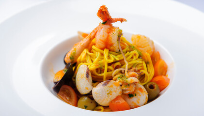 pasta with seafood. beautiful pasta with seafood on a big white plate on the table.eating diet healthy eating restaurant business concept.