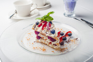 beautiful dessert. dessert on a plate with raspberry strawberries blueberries pine nuts and mint poured over chocolate sauce. food restaurant diet balanced nutrition