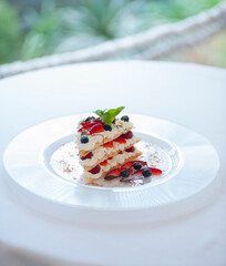 beautiful dessert. dessert on a plate with raspberry strawberries blueberries pine nuts and mint poured over chocolate sauce. food restaurant diet balanced nutrition