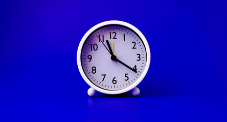 white clock placed on a blue background The concept of time and the importance of time