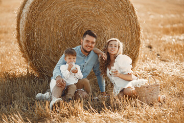 Naklejka na ściany i meble Family in a picnic in a wheat field