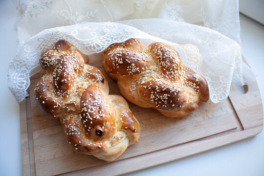 Two challah breads for Shabbat on wood cutting board