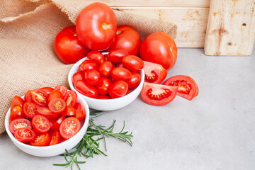 ripe and juicy tomatoes on farm table with burlap and wood with copy space