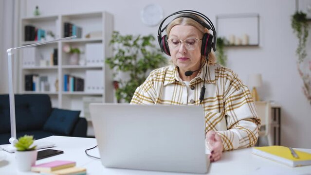 Woman in her 50s working as call center operator, work from home, tech support