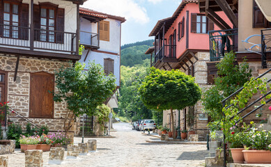 Fototapeta na wymiar Greece, Arnaia village Chalkidiki. Mansion with loggia, tile roof, internal covered balcony, plant.