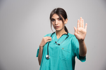 Female doctor posing on gray background