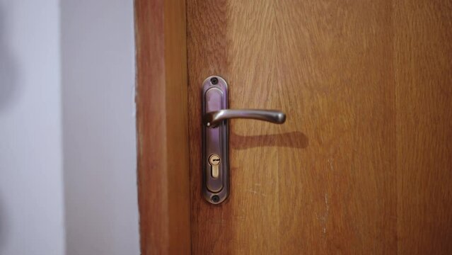 Close-up of person exiting house or office, pulling door handle, entrance