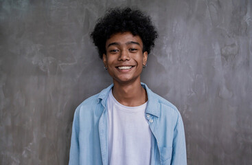 Portrait of young smile handsome black African American man on gray wall background. Happy afro guy...