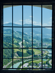 Magnificent view of the Salzach River and surroundings through a barred window from the medieval Hohenwerfen Castle in Austria