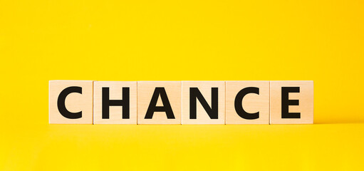 Chance symbol. Concept word Chance on wooden cubes. Beautiful yellow background. Business and Chance concept. Copy space.