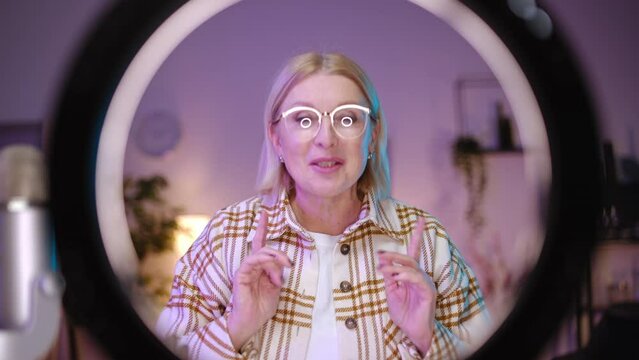 Smiling woman in her 50s recording makeup tutorial, beauty channel, vlog