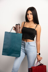 Beautiful woman holding coffee and shopping bags