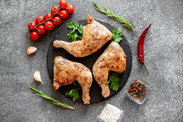 Grilled chicken legs on stone background