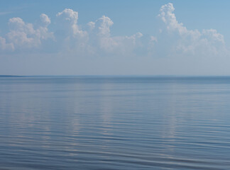 Calm on Lake Onega in Karelia, northwest Russia in summer. Nice, hot, sunny weather in July. Clouds are reflected in the water