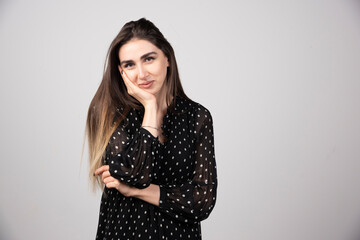 Pleasant looking young brunette woman standing and posing