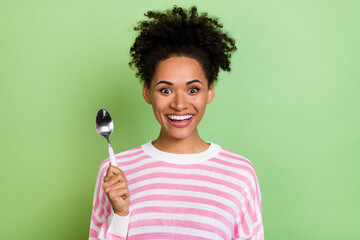 Photo of pretty impressed woman wear striped sweater rising spoon isolated green color background