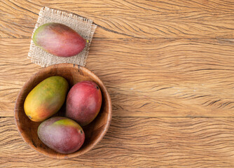 Obraz na płótnie Canvas A group of ripe mangos over wooden table with copy space