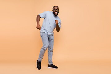 Full size photo of impressed young beard guy dance wear eyewear t-shirt jeans shoes isolated on...