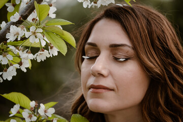 Woman portrait with eyes closed enjoying flowering spring