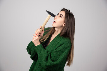 Obraz premium A young woman holding hammer at hands
