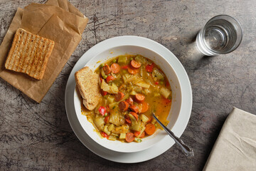 Vegetable soup with sliced Debrecziner sausages, a spicy Hungarian boiled sausage specialty. Top view.