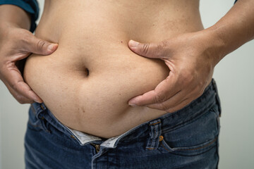 Naklejka premium Overweight Asian woman show fat belly at office.