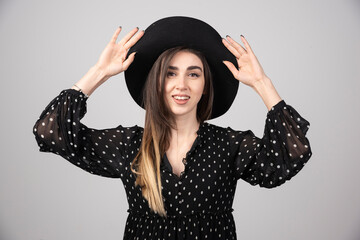 Beautiful young woman in black hat looking at camera