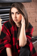 Fototapeta premium Young woman model posing with checkered plaid near Christmas balls