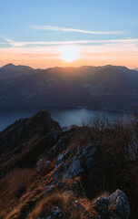 View of Lake Iseo at sunset, with the alps framing it, near the town of Zone, Italy - February 2022.