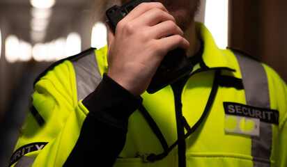 Security guard using a walkie-talkie radio - obrazy, fototapety, plakaty