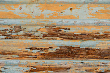 Texture of vintage wooden boards with cracked paint in blue and orange colors. Retro background with old wooden boards in different colors.