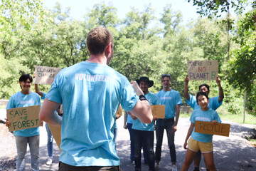 Group of volunteer protest against earth pollution and global warming. Back of head leader standing and raising fists up to cheer up and motivate team to do charity work and save our planet.