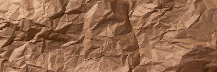 Brown crumpled, wrinkled recycle craft paper texture background banner. Wide panoramic header