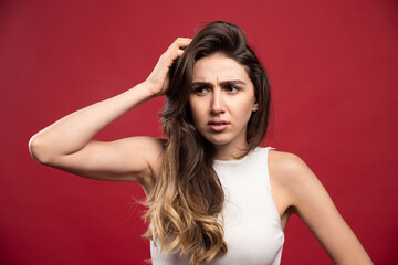 Young pretty brunette woman model posing on a red background