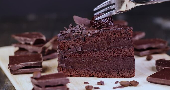 separate a piece of chocolate cake with chocolate filling with a fork