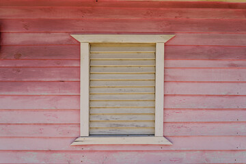 Obraz na płótnie Canvas Rustic yellow and pink wooden house with wooden shutters. Dominican Republic.