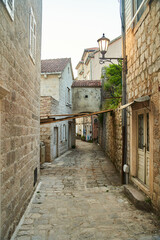 Fototapeta na wymiar Empty narrow street with ancient stone buildings in old town Herceg Novi, Montenegro. High quality photo