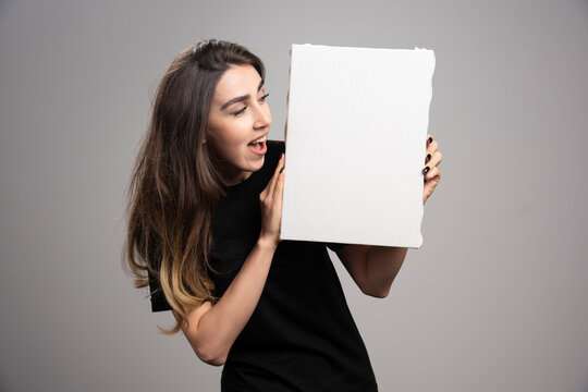 Young woman with happy epression holding canvas