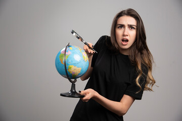 Beautiful young woman posing with globe