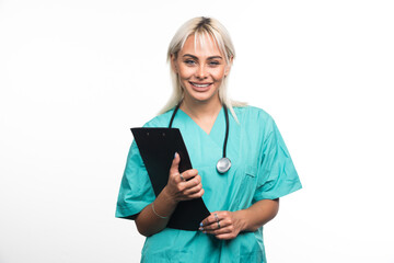 Smiling female doctor holding a clipboard on white background