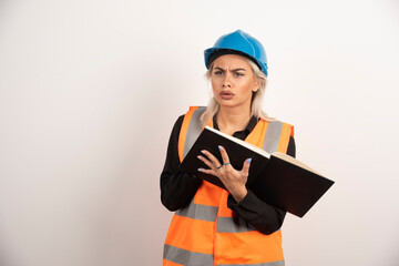 Displeased worker with notebook standing on white background