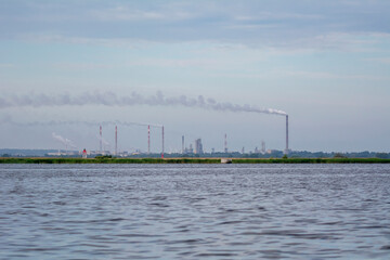 View of fuming chimneys of the chemical plant at Police over the water of Szczecin Bay.