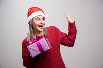 Portrait of woman with gift box greeting someone
