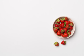 Bowl with fresh strawberries on white background, top view