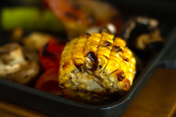 Grilled corn cob and vegetables on grill pan